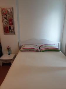 - un lit blanc avec un livre au-dessus dans l'établissement Room in Condo - T8impact Challenger Mueang Thon Thani Free WIFI, à Nonthaburi