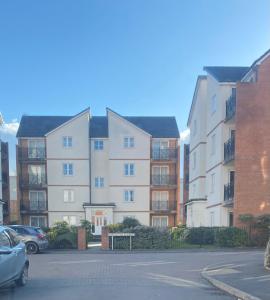 an apartment building with cars parked in a parking lot at Amazing 2-Bed City Centre Apt with Parking in Spon End