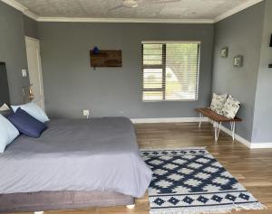 a bedroom with a bed and a window and a rug at 59 On Gail in Ballito
