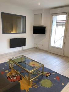 uma sala de estar com uma mesa de vidro e uma janela em Marseille bleue em Marselha