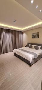 1 dormitorio con 1 cama grande en una habitación en شقق ظلال النخيل, en Al Khobar