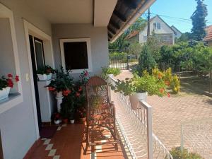 a porch with two chairs and potted plants at Erika Apartman in Tihany
