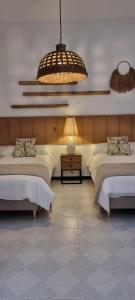 um quarto com 2 camas e um lustre em La Casa del Moral em Isla del Moral