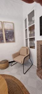 uma sala de estar com uma cadeira e uma televisão em La Casa del Moral em Isla del Moral