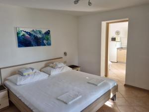 a bedroom with a large white bed with two pillows at Guesthouse Dominović in Brela