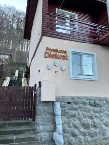 a building with a sign on the side of it at Pensiunea Diskret in Sovata