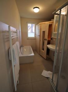 ein Badezimmer mit einer Badewanne und einem Waschbecken in der Unterkunft K108 EG - Exclusive Ferienwohnung mit Sauna in Roebel in Röbel