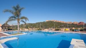 a large blue swimming pool with a mountain in the background at Duquesa Village 7,19,12 in Manilva