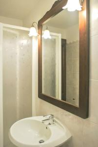 ローマにあるラリサルームズのバスルーム(白い洗面台、鏡付)