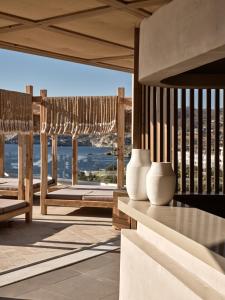 dos jarrones blancos sentados en una mesa en un balcón en Seaside A Lifestyle Resort - Adults Only en Agia Pelagia