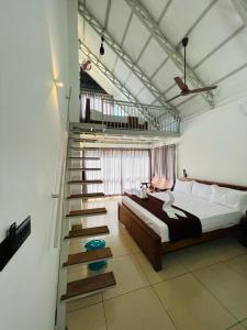 a bedroom with a bed and a staircase in it at Wild Brooke Guest House in Vythiri