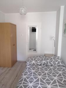 a white bedroom with a bed and a mirror at pokoje u AniS in Świnoujście