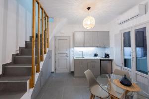 una cocina con mesa y sillas y una escalera en Golden View Suites en Vóthon