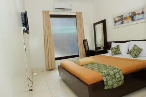 a small bedroom with a bed and a window at The Kirana Purnama Semarang in Semarang