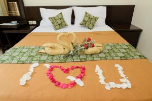 a bed with two swans made to look like hearts at The Kirana Purnama Semarang in Semarang