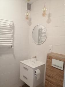 a white bathroom with a sink and a mirror at pokoje u AniS in Świnoujście