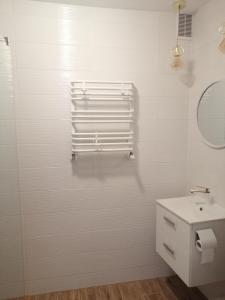 a white bathroom with a sink and a mirror at pokoje u AniS in Świnoujście
