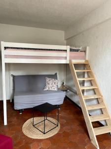 a bedroom with two bunk beds and a staircase at Maison à proximité de Barbizon / Fontainebleau / A6 in Saint-Sauveur-sur-École