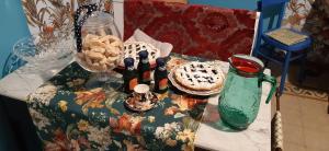 un tavolo con bottiglie di vino e un vaso di B&B Leopardi a Montefiore dellʼAso