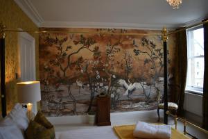 een slaapkamer met een schilderij aan de muur bij Carlton House - Spacious 4 Bed Victorian townhouse in Harrogate