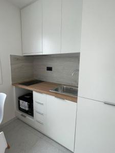 a kitchen with white cabinets and a sink at Seaview by Agora Flats in Thessaloniki