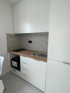 a kitchen with white cabinets and a sink at Seaview by Agora Flats in Thessaloniki +5 photos