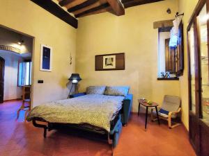 Casa Matteo San Gimignano Apartments في سان جيمنيانو: غرفة نوم بسرير وطاولة وكرسي