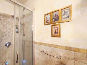 uma casa de banho com chuveiro e fotografias na parede em Casa Matteo San Gimignano Apartments em San Gimignano