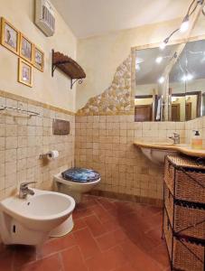 uma casa de banho com 2 WC, um lavatório e um espelho. em Casa Matteo San Gimignano Apartments em San Gimignano