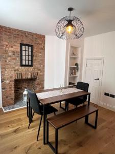 una sala da pranzo con tavolo, sedie e muro di mattoni di Beautiful house on the River Itchen a Winchester