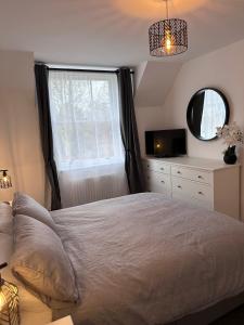 a bedroom with a large bed and a window at Beautiful house on the River Itchen in Winchester