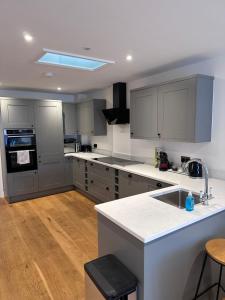 a kitchen with gray cabinets and white counter tops at Beautiful house on the River Itchen in Winchester