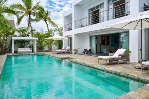 a swimming pool in front of a villa at Villa Horizon by Dream Escapes, Beachfront Villa in Pointe aux Cannoniers