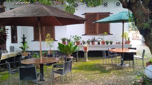 two tables and chairs with umbrellas in a courtyard at Valhalla Bed & Breakfast in Salatiga