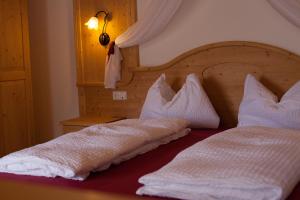 um quarto com 2 camas e almofadas brancas em La Fagitana em Faedo