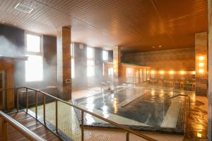 a large swimming pool in a building with at Ooedo Onsen Monogatari Premium Kinosaki in Toyooka