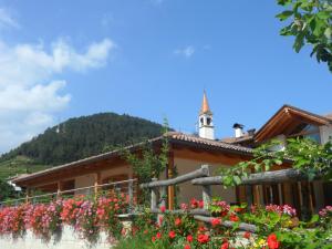 a building with a bunch of flowers in front of it at La Fagitana in Faedo