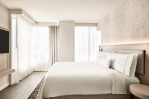 a bedroom with a large white bed and windows at The Westin Tempe in Tempe