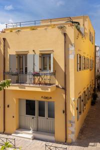 un edificio amarillo con un balcón en el lateral. en Flâneur en La Canea