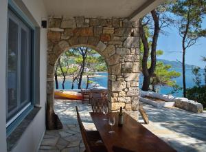 a patio with a table and a stone wall at Kavos Villa in Aghios Petros Alonissos