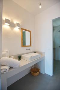 a bathroom with a white sink and a mirror at Kavos Villa in Aghios Petros Alonissos