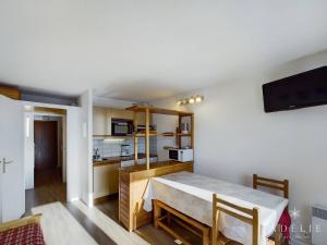 a living room with a table and a kitchen at Studio Montvalezan-La Rosière, 1 pièce, 6 personnes - FR-1-398-502 in La Rosière