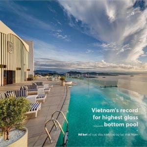 uma piscina num hotel com cadeiras e o oceano em AZ five stars Ocean View Apartment em Nha Trang