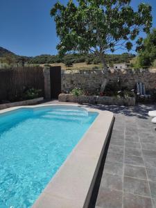 una piscina en un patio con una pared de piedra en Vivienda Rural Sierra de Cádiz, Cabeza del Rey en Prado del Rey