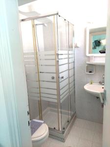 e bagno con doccia, servizi igienici e lavandino. di Seatincenter Rooms a Mykonos Città