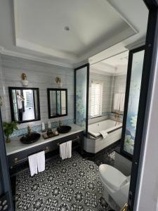 a bathroom with two sinks and a bath tub at Vườn Vua Resort & Villas in Phú Thọ