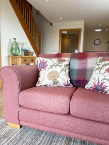 un divano viola con 2 cuscini in soggiorno di Woodside Apartments a St Andrews