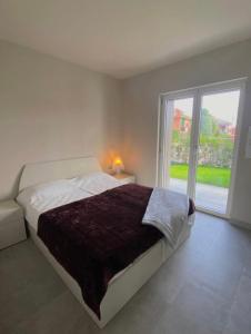 a bedroom with a bed and a large window at Grazioso appartamento con giardino privato in Asti