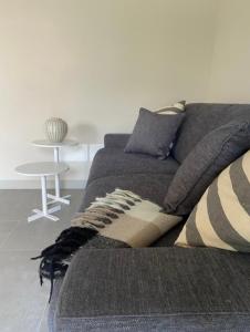 un sofá en una sala de estar con mesa en Grazioso appartamento con giardino privato en Asti