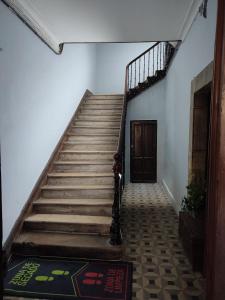 a staircase in a building with a wooden door at Hostal la Fruta Nueva apertura in Avilés
